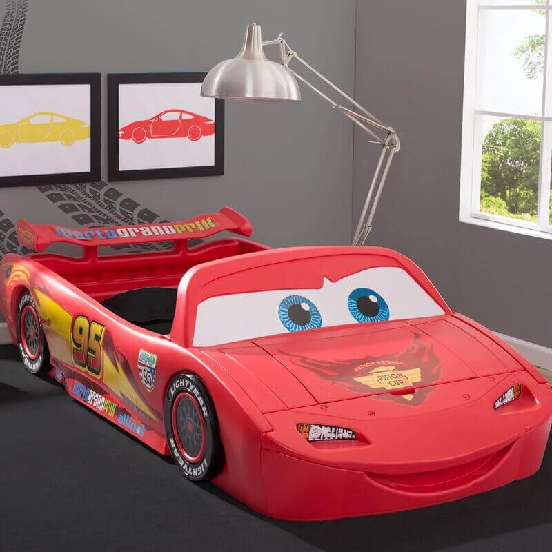 Red racecar bed with storage bin in the hood.